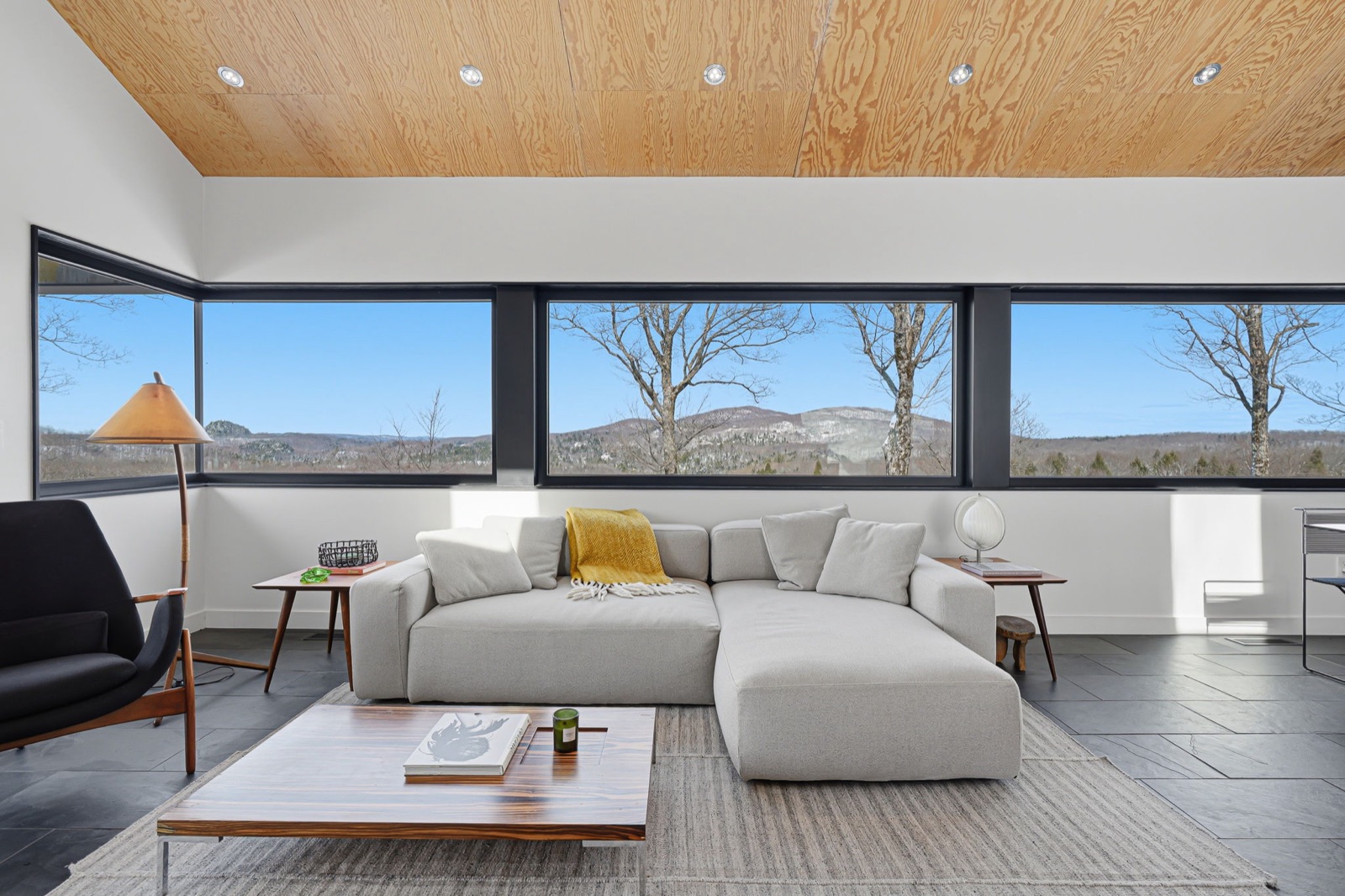 Salon lumineux avec fenêtres panoramiques sur les montagnes